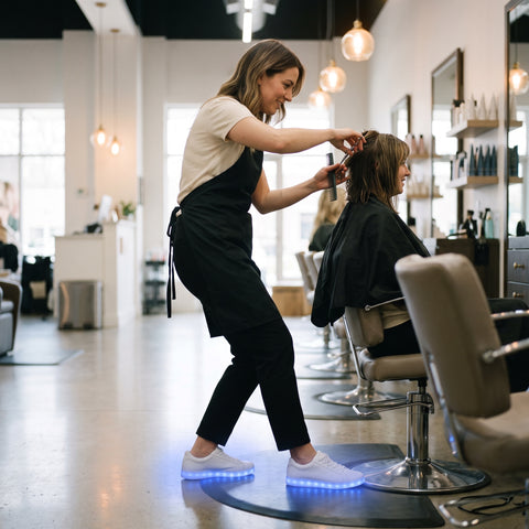 A hair stylist on her feet at work in a salon