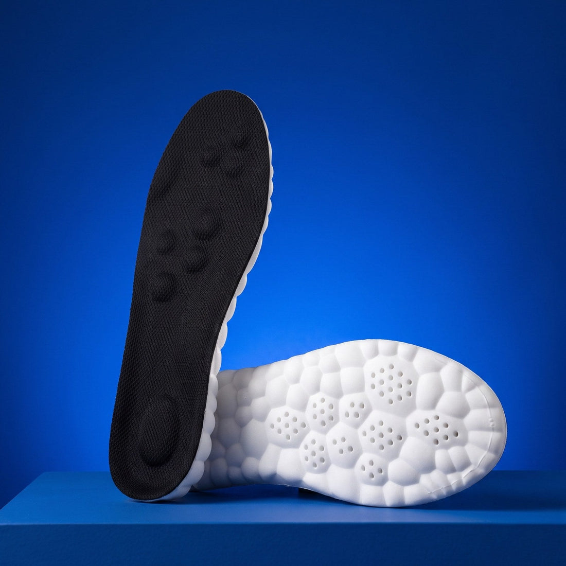 SoftInch Comfort Insoles in black on a blue stand, the massage dot top and the cloud foam underside