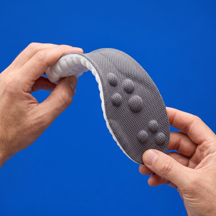 Two hands bending a gray SoftInch insole