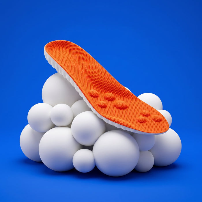 An orange SoftInch insole resting on soft white foam balls on cobalt blue