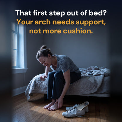 A woman sitting on the edge of her bed in the morning, holding her foot after her first step, her worn sneakers and old flat insole on the floor