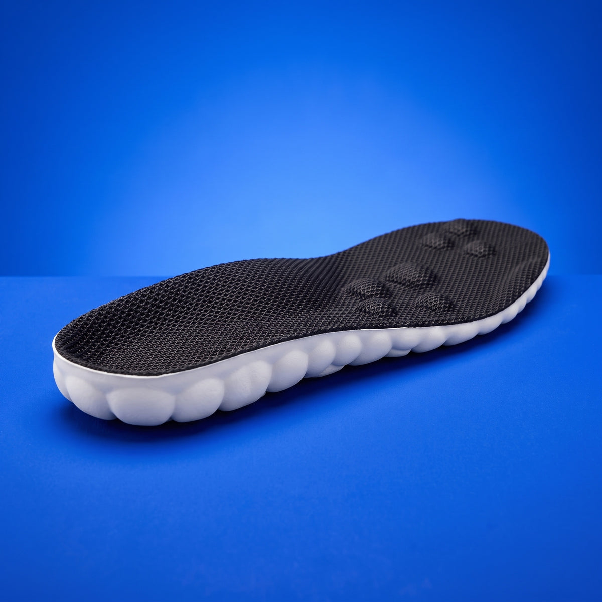 A SoftInch Comfort Insole: a black mesh top over thick white cloud foam